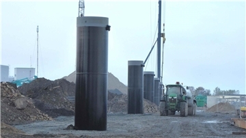 Neuer BLG-Südhafen „Roter Sand“ in Bremerhaven startet Anfang 2026 Baustelle im neuen BLG-Südhafen „Roter Sand“ in Bremerhaven: Mehrere massive schwarze Hochpoller stehen in einer Reihe, im Hintergrund sind Baumaschinen, Erdhaufen und ein Traktor mit Anhänger zu sehen.