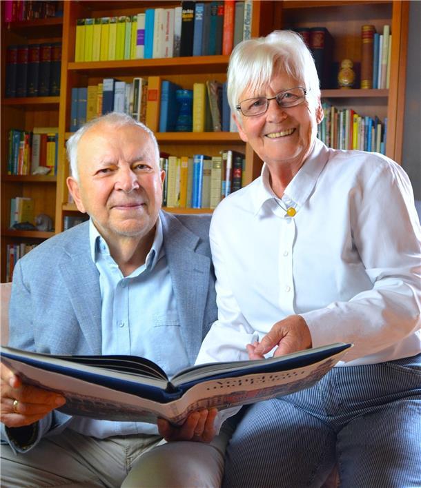 Ein älteres Ehepaar sitzt eng beisammen. Sie halten ein geöffnetes Buch in den Händen. Elke und Dr. Volker Barthel feiern am heutigen Donnerstag, 24. Juli, ihre diamantene Hochzeit.