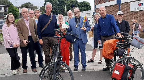 Eine größere Menschengruppe, davor zwei Räder