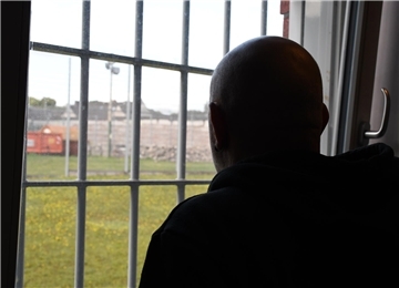 Mann am vergitterten Fenster. 