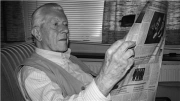 Ein älterer Herr liest Zeitung.