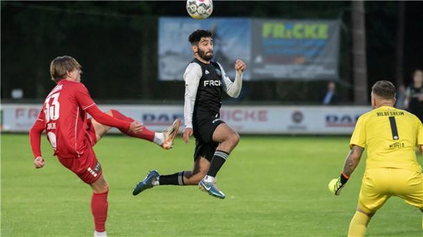 Ein Mann in einem Trikot springt mit dem Kopf an einen Ball.