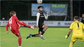 Ein Mann in einem Trikot springt mit dem Kopf an einen Ball.