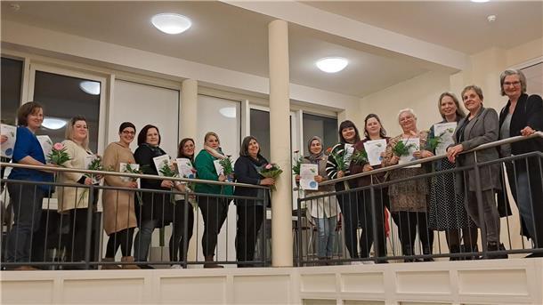13 Frauen an einem Geländer. 