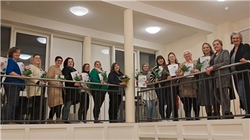 13 Frauen an einem Geländer. 