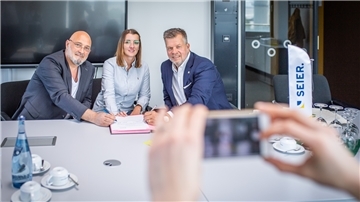 Erinnerungsfoto: Hochschulrektor Prof. Alexis Papathanassis (links) unterzeichnet mit Ulrich Seier die Kooperation. Biljana Scholz wird die erste duale Studentin sein.