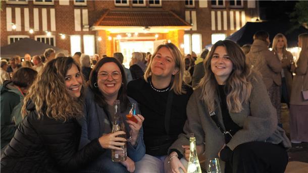 Vier Frauen stehen auf dem Weinfest in Nordenham und trinken Wein.