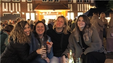 Vier Frauen stehen auf dem Weinfest in Nordenham und trinken Wein.