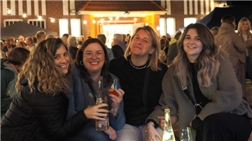 Vier Frauen stehen auf dem Weinfest in Nordenham und trinken Wein.