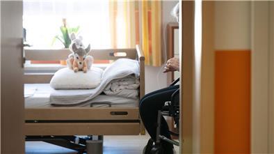 Eine Heimbewohnerin sitzt in dem Zimmer ihres Plegeheims.