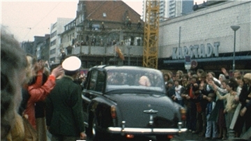 Foto stammt aus den 60er Jahren und zeigt ein Auto, umsäumt von jubelnden Menschen. 