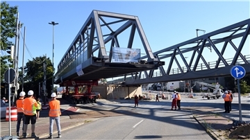 Eine große Stahlbrücke wird an ihren Platz gefahren.
