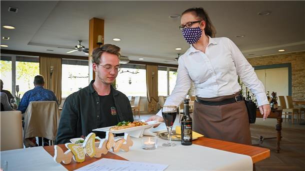Essen zum Testen in Corona-Zeiten: Volontär Jannik Sauer wird im Restaurant zur Mühle in Sievern von Monique Hildebrandt bedient.