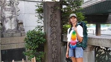 Eva Fritz hält eine Kette aus bunten  Papierkranichen in der Hand. Sie will von Tokio aus zweieinhalb Monate lang mit Rucksack und Zelt 1000 Kilometer über Kyoto bis nach Hiroshima wandern.