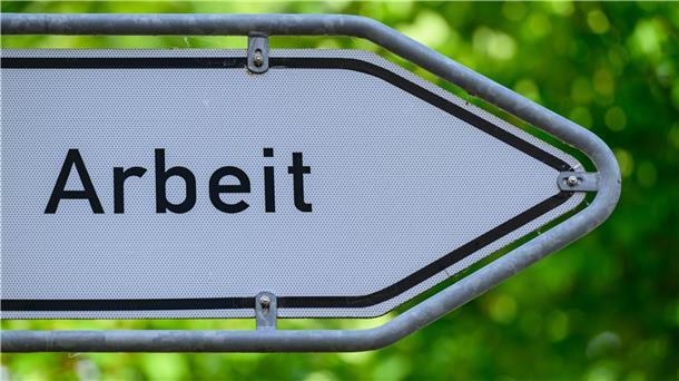 Blick auf einen Wegweiser mit der Aufschrift „Arbeit“. 