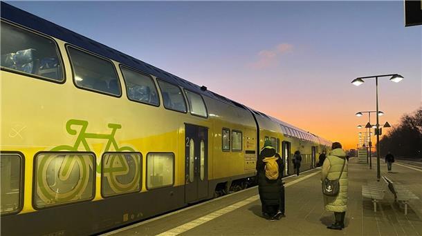 Fahrgäste warten geduldig auf den verspäteten RE5 am Bahnhof.