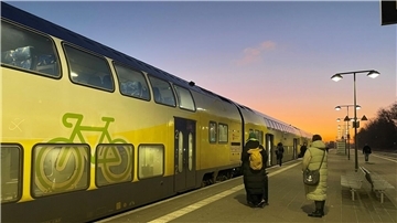 Fahrgäste warten geduldig auf den verspäteten RE5 am Bahnhof.