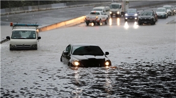 Fahrzeuge stehen im Hochwasser einer überschwemmten Straße im neuseeländischen Auckland.