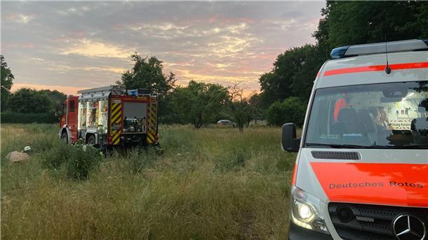 Vater-Kind-Zeltlager endet mit Tragödie Fahrzeuge von Feuerwehr und Deutsches Rotes Kreuz stehen an einer Wiese.