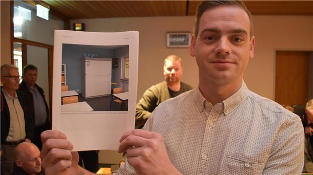 Falko Böseler von der Installationsfirma aus Stadland zeigt ein Prospekt-Bild der Lüftungsgeräte, mit denen Stadlands Schulen und Kitas ausgestattet werden sollen. 