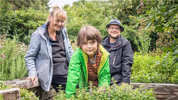 Familie Weikusat in ihrem Naturgarten-Paradies, das sie gemeinsam mit zwölf anderen Erwachsenen und Kindern bewirtschaften. Der Garten ist für die Familie – besonders seit der Corona-Pandemie – ein wichtiger Erholungsort geworden.