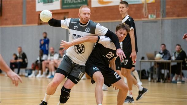 Zwei Männer in schwarz-weißen Trikots kämpfen um einen kleinen Ball.