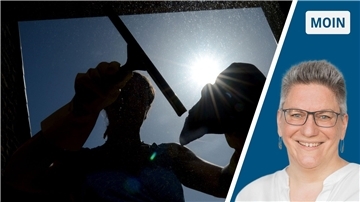 Frau putzt im Gegenlicht Fenster