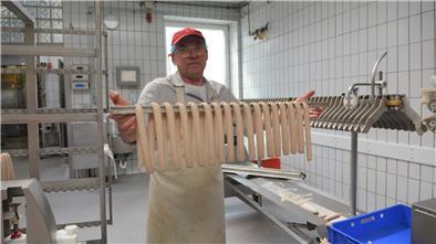 Fertig zum Brühen: Wolfgang Tiegel zeigt die abgefüllten Würstchen.