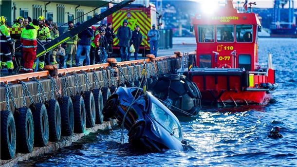 Feuerwehrleute bergen das versunkene Auto aus dem Fjord.