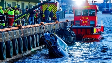 Feuerwehrleute bergen das versunkene Auto aus dem Fjord.