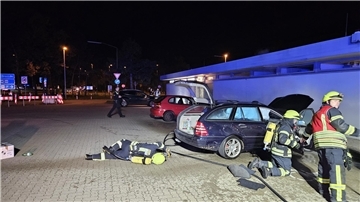 Feuerwehrleute löschen am Freitagabend ein brennendes Auto auf der Rastanlage Grundbergsee Nord.