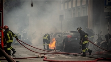 Feuerwehrleute löschen brennende Fahrzeuge.