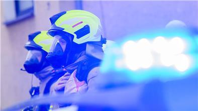 Feuerwehrleute stehen an einem Einsatzort.