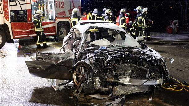 Feuerwehrleute stehen im April 2022 bei Monheim nach der Kollision hinter dem Autowrack einer 54 Jahre alten Frau. Sie starb noch am Unfallort.
