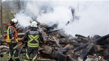 Feuerwehrleute stehen neben den noch rauchenden Trümmern des ehemaligen Hauses des „Kannibalen von Rotenburg“.