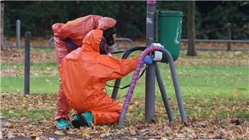 Feuerwehrleute überprüfen eine Mülltonne.
