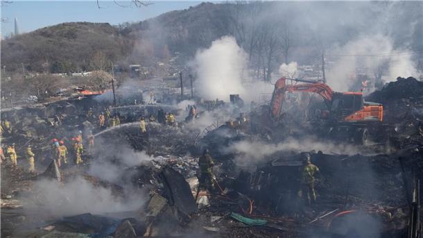 Feuerwehrleute und Rettungskräfte sind am Brandherd in Guryong im Einsatz.