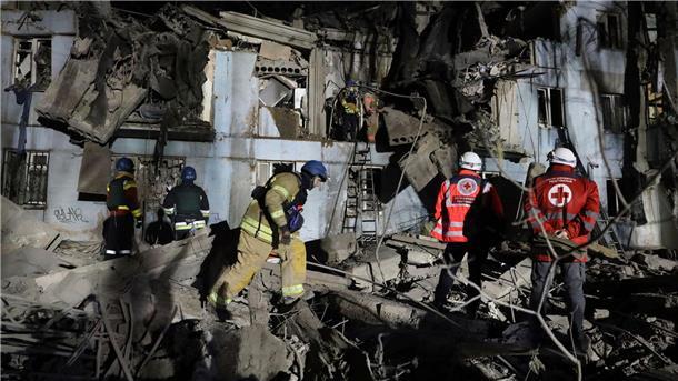 Feuerwehrleute vor einem beschädigten Haus nach dem mutmaßlich russischen Raketenangriff in Saporischschja.