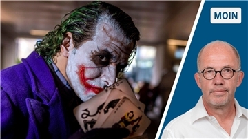 Der Joker aus „Batman" hält Spielkarten in der Hand. 