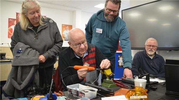 Filigranes Handwerk: Werner Abed (sitzend) schwingt Lötkolben und Schraubenzieher, Gaby Momberg-Greschke (von links), Philipp Tenhaef und Werner Brunkhorst beobachten interessiert die Reparatur.