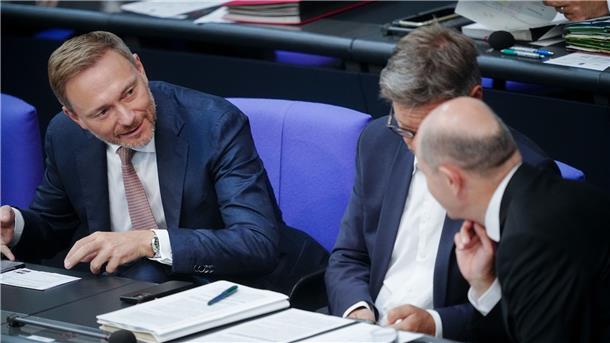 Finanzminister Christian Lindner (l) spricht mit Bundeskanzler Olaf Scholz (r). Dazwischen sitzt Wirtschaftsminister Robert Habeck (Archivbild).
