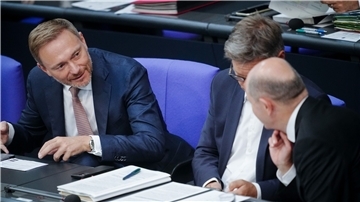 Finanzminister Christian Lindner (l) spricht mit Bundeskanzler Olaf Scholz (r). Dazwischen sitzt Wirtschaftsminister Robert Habeck (Archivbild).