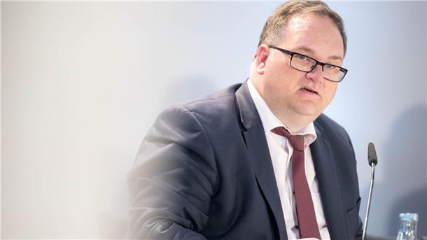 Bremerhaven und Bremen versuchen es mal wieder ohne neue Schulden Mann vor einem Mikrofon.
