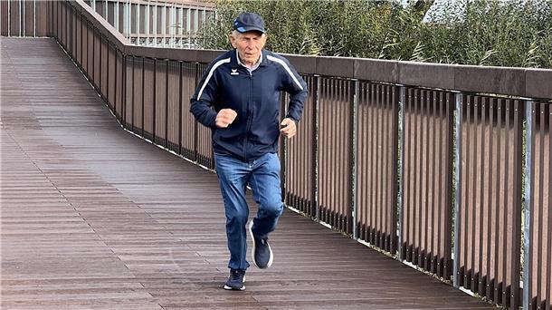 Ein Mann joggt über eine Brücke.