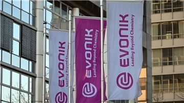 Flaggen mit dem Firmenlogo von Evonik vor der Zentrale des Unternehmens in Essen.
