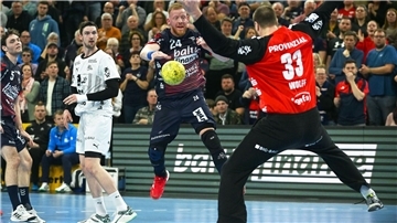 Flensburgs Jim Gottfridsson (M) überwindet Kiels Torwart Andreas Wolff (r).