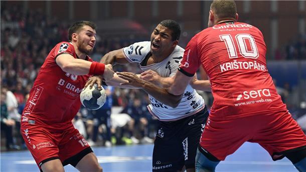 Flensburgs Mads Mensah Larsen (M) setzt sich gegen die Melsunger Elvar Örn Jonsson (l) und Dainis Kristopans durch.