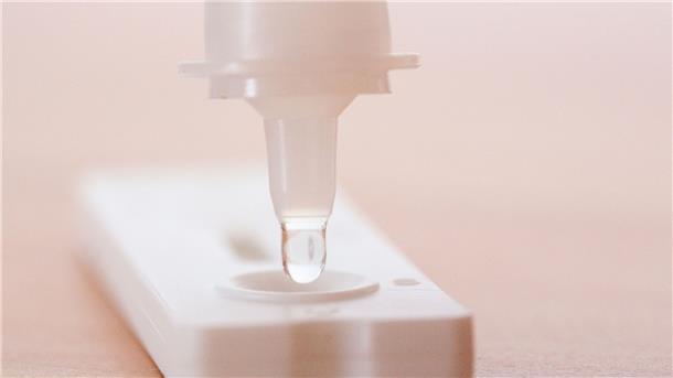 Zahl der Corona-Neuinfektionen abermals gesunken Flüssigkeit wird auf einen Antigen-Schnelltest gegeben.