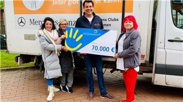 Menschen halten einen Spenden Scheck.