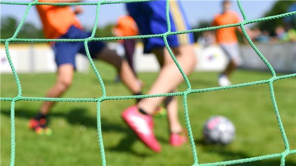 Fußballspieler durch das Netz eines Tores betrachtet.